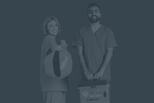 Picture of female nurse holding bag of waste next to male nurse holding Sharpsmart container