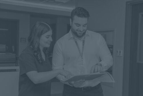 Female nurse reviewing information with male Sharpsmart employee