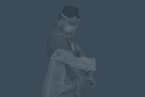 Male in a a surgical mask and cover removing his scrubs